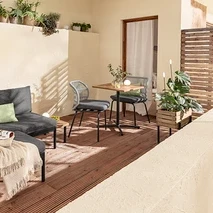 Zariadenie balkóna s variabilnou súpravou balkónového lounge nábytku Elin, stolíkom, stoličkami s textilným výpletom, 2 vankúšmi do exteriéru, kvetináčom a solárnymi zapichovacími svietidlami.