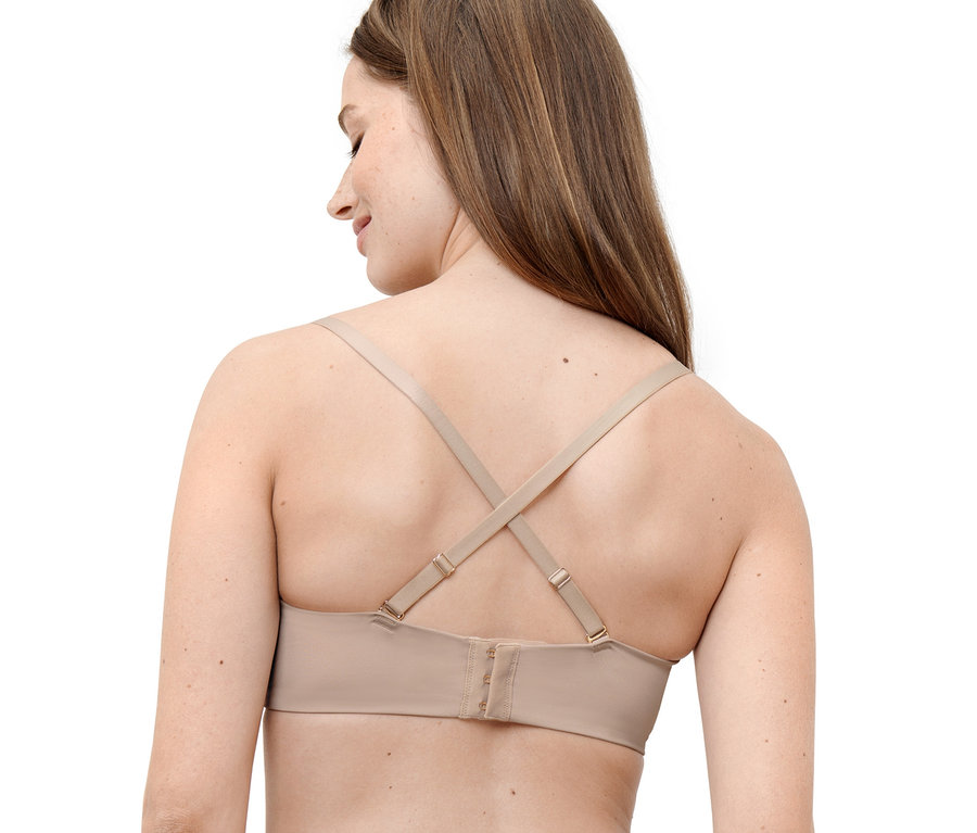 Žena má na sebe multifunkčnú podprsenku telovej farby so skríženými ramienkami na chrbte.