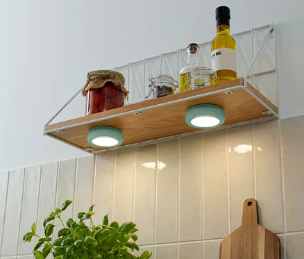 Na polici sú poháre s potravinami a fľaše s olejom, pod nimi sú dve tyrkysové 2 LED-Multifunktionsleuchten.