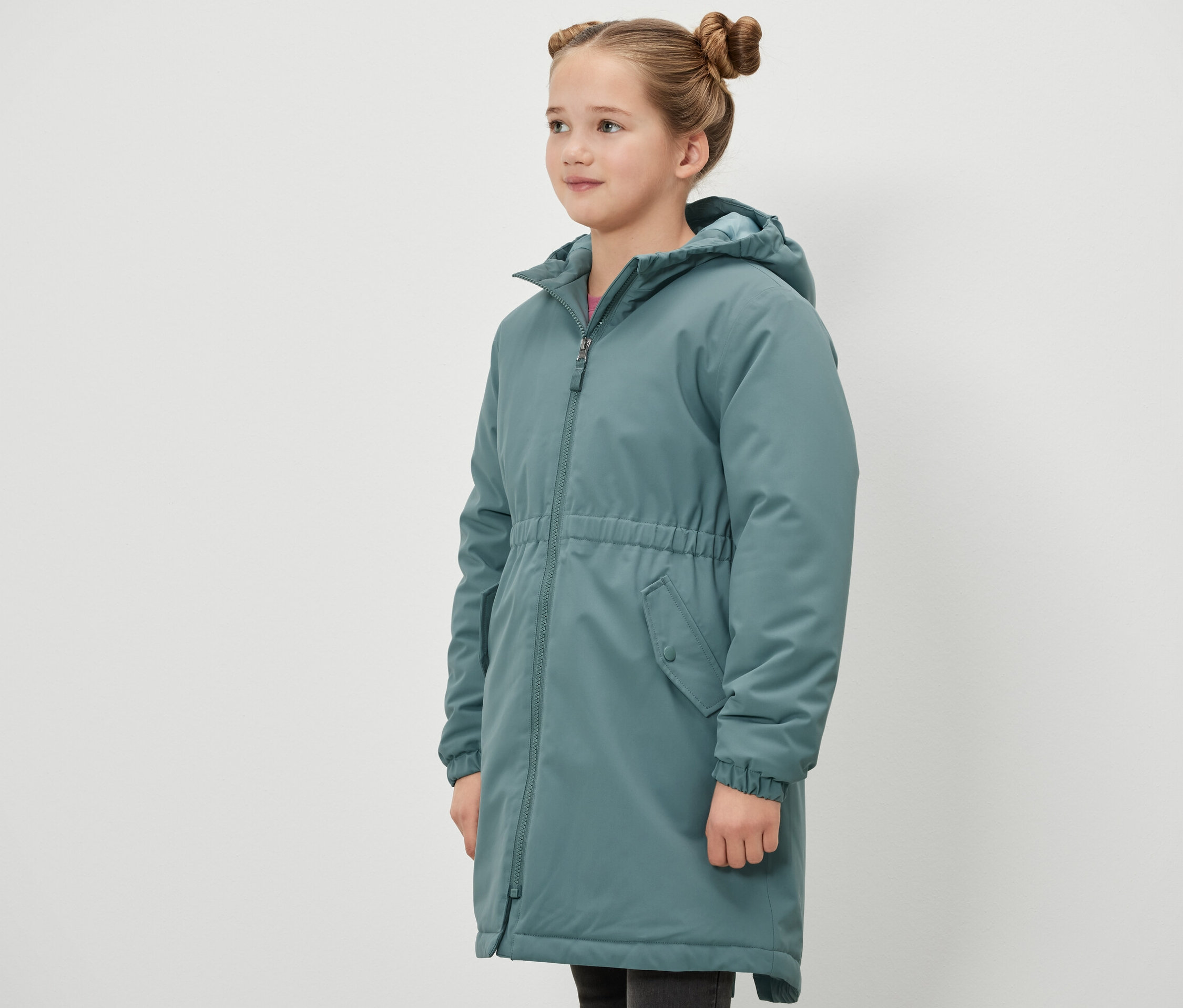 Dievča stojí bokom a má na sebe zelenú termo parku Kinder-Thermoparka.