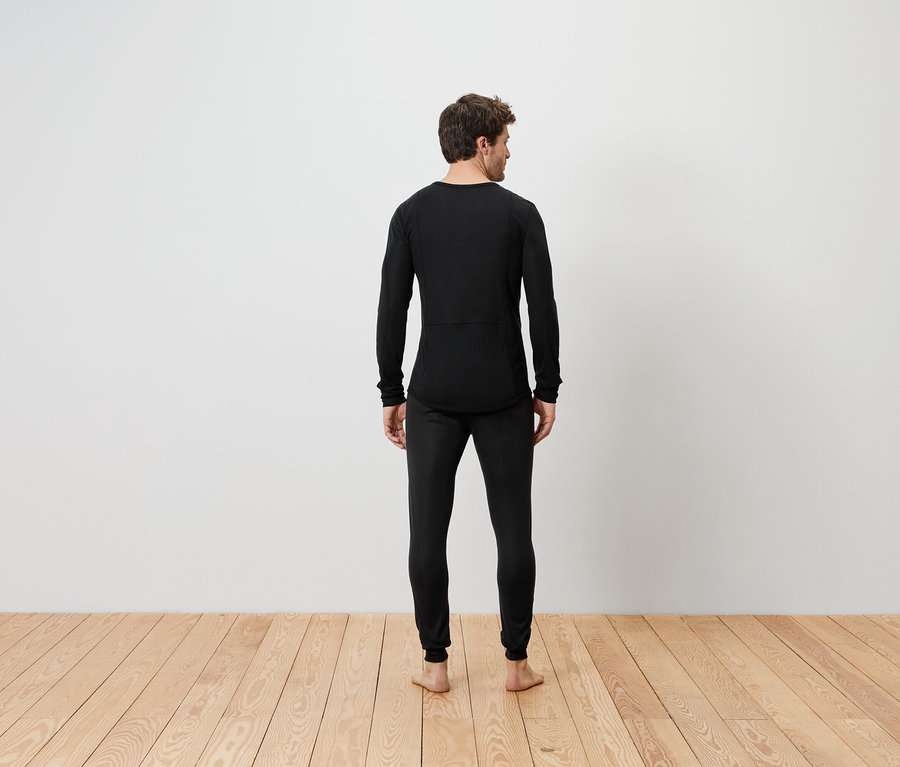 Muž stojí chrbtom, oblečený v čiernom termobielizni.