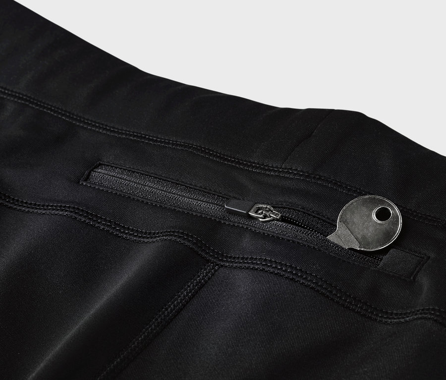 Detail čiernych legín s vreckom na zips a kľúčom.