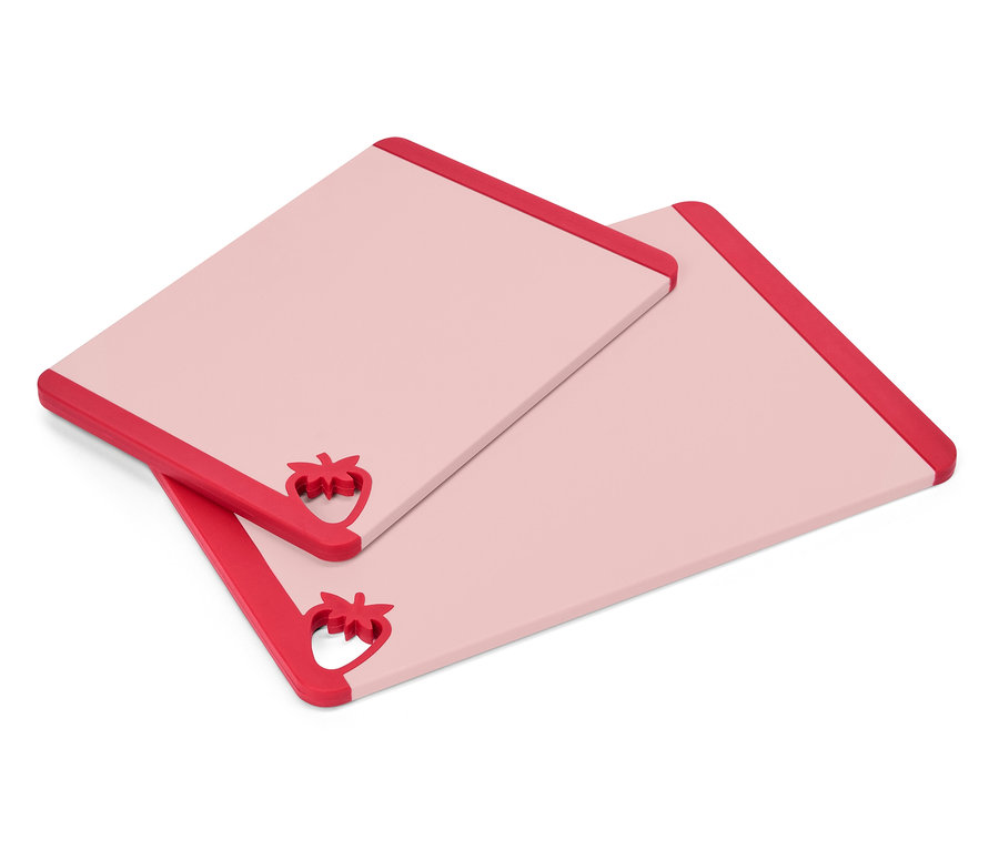 Dve obdĺžnikové, ružové dosky na krájanie s červenými jahodovými akcentmi v jednom rohu ležia na sebe.