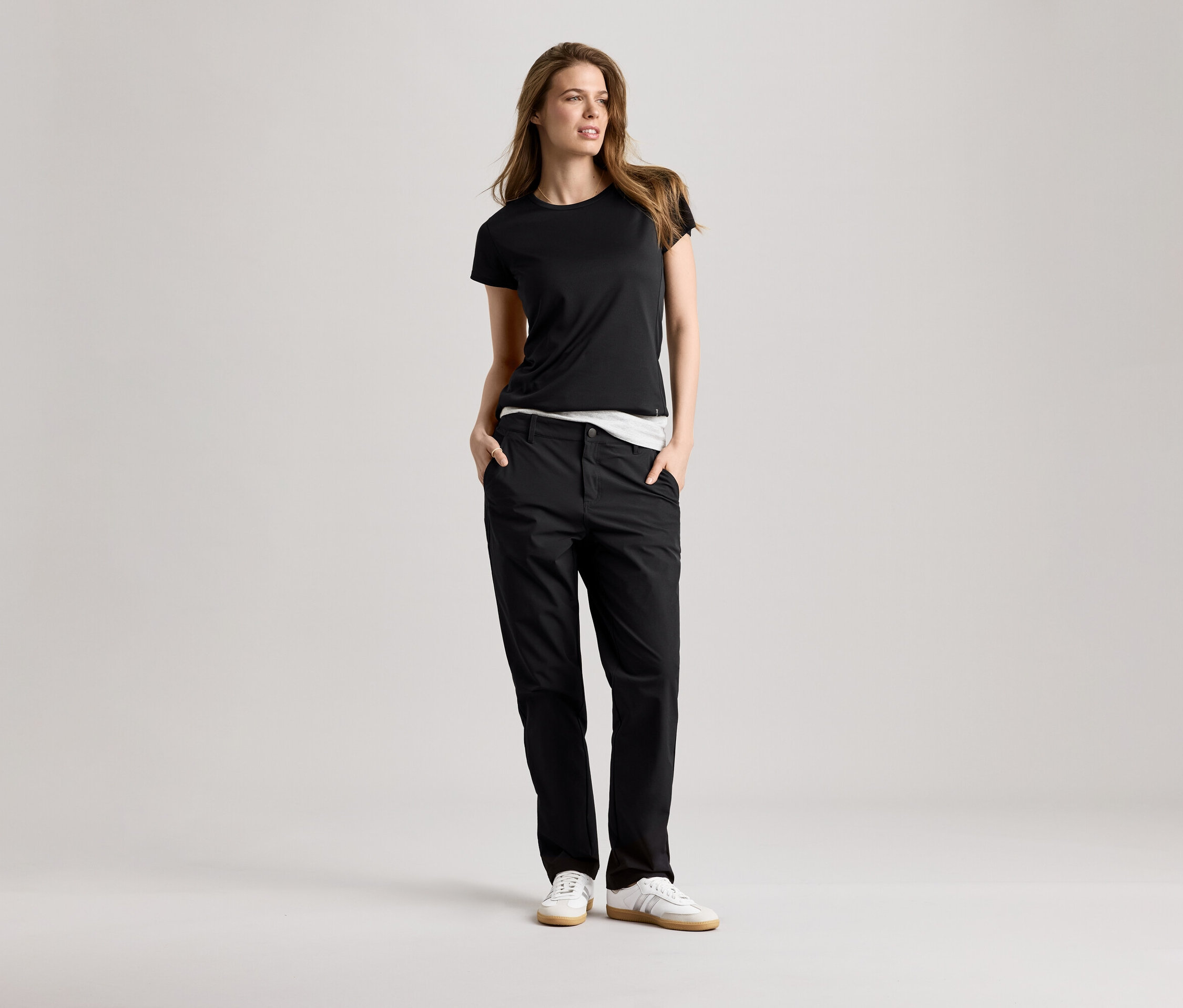 Žena v čiernom športovom tričku a nohaviciach. Športové tričko je čierne.