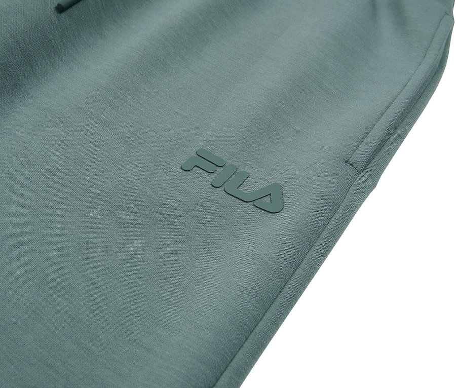 Detailný záber na tyrkysové tepláky Fila so šnúrkou.