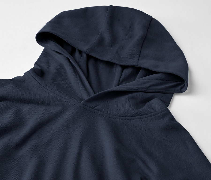 Detail modrej mikiny s kapucňou na bielom pozadí.