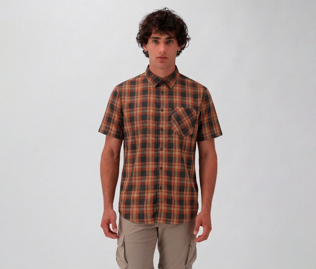 Muž má na sebe pánsku košeľu s krátkymi rukávmi CMP s hnedým a sivým károvaným vzorom a béžové cargo nohavice na bielom pozadí.