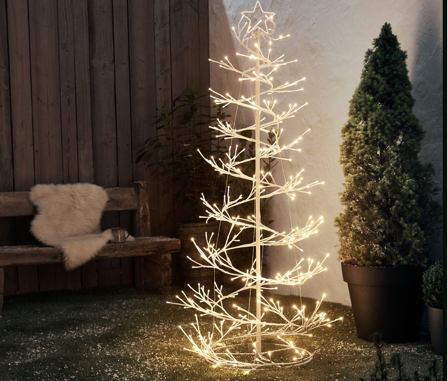 LED Strom »Špirála« stojí na trávniku vedľa lavičky.