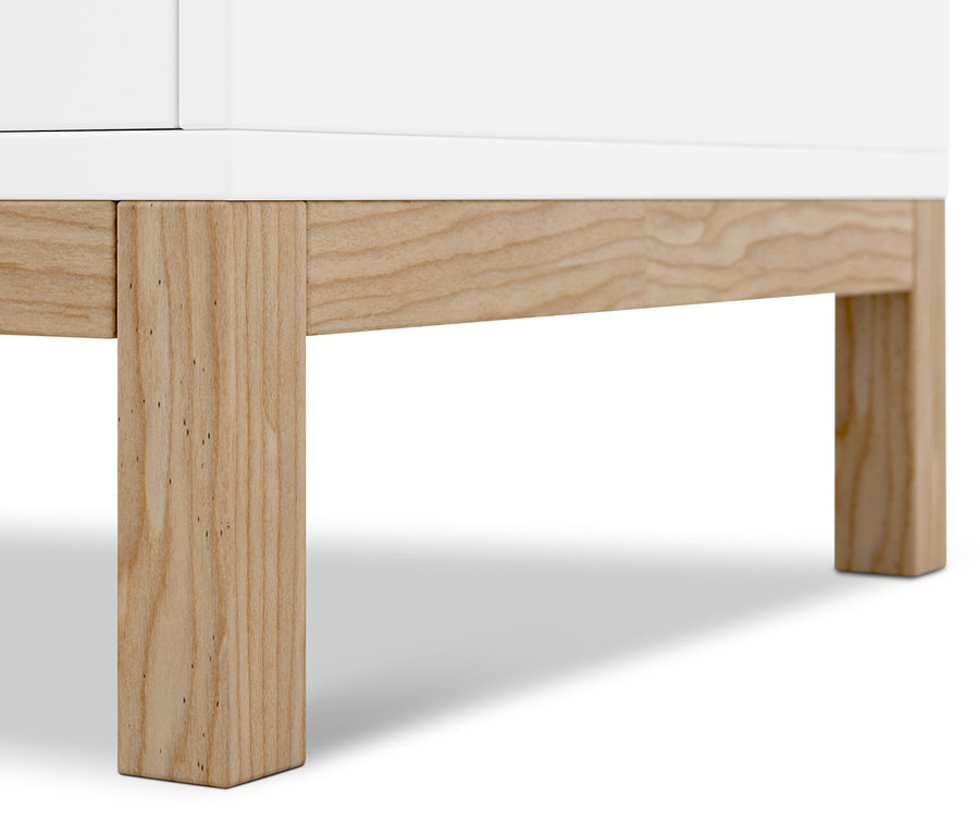 Detail bieleho príborníka s drevenými nohami.