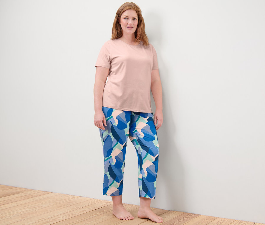 Žena stojí a má na sebe pyžamo.