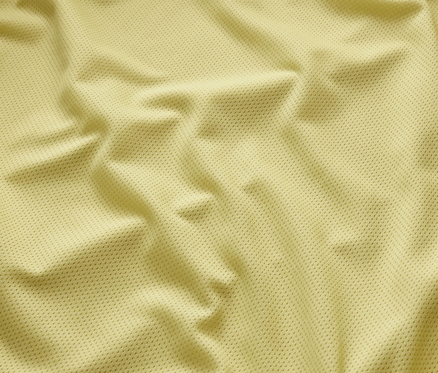 Detail žltej bundy do dažďa s textúrou.