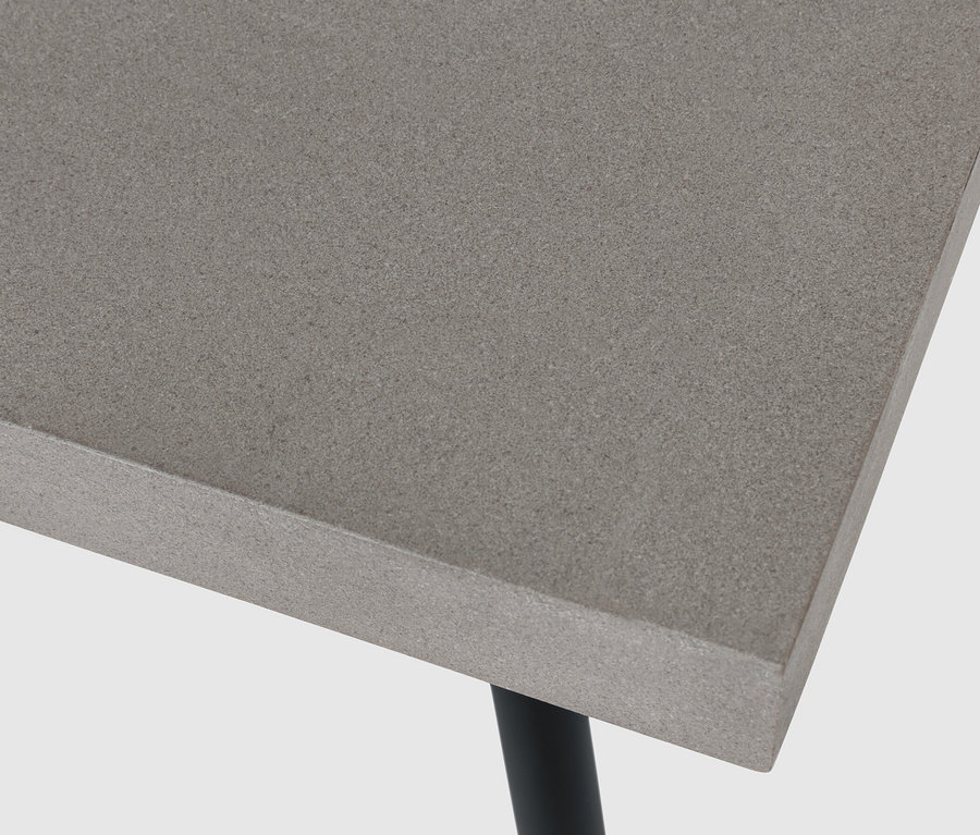 Detail konferenčného stolíka s doskou stola z polycementu a čiernymi nohami.