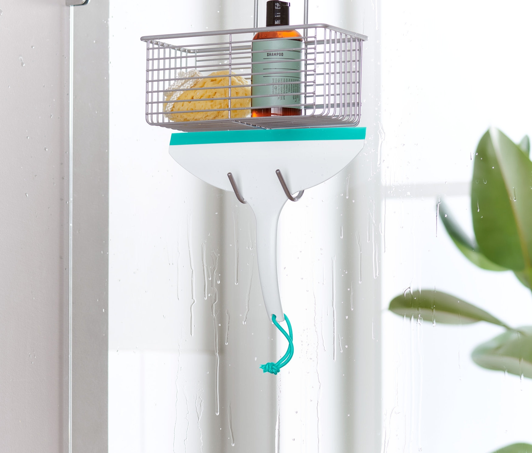 Kúpeľňová stierka visí na dverách sprchy.