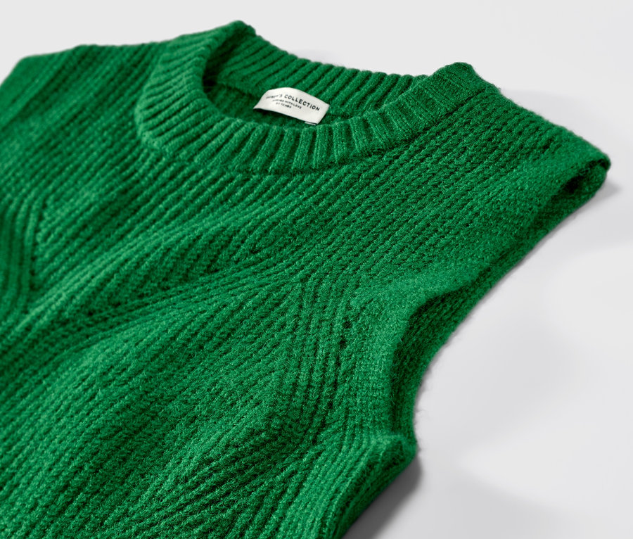 Detailný záber na zelenú pletenú vestu.
