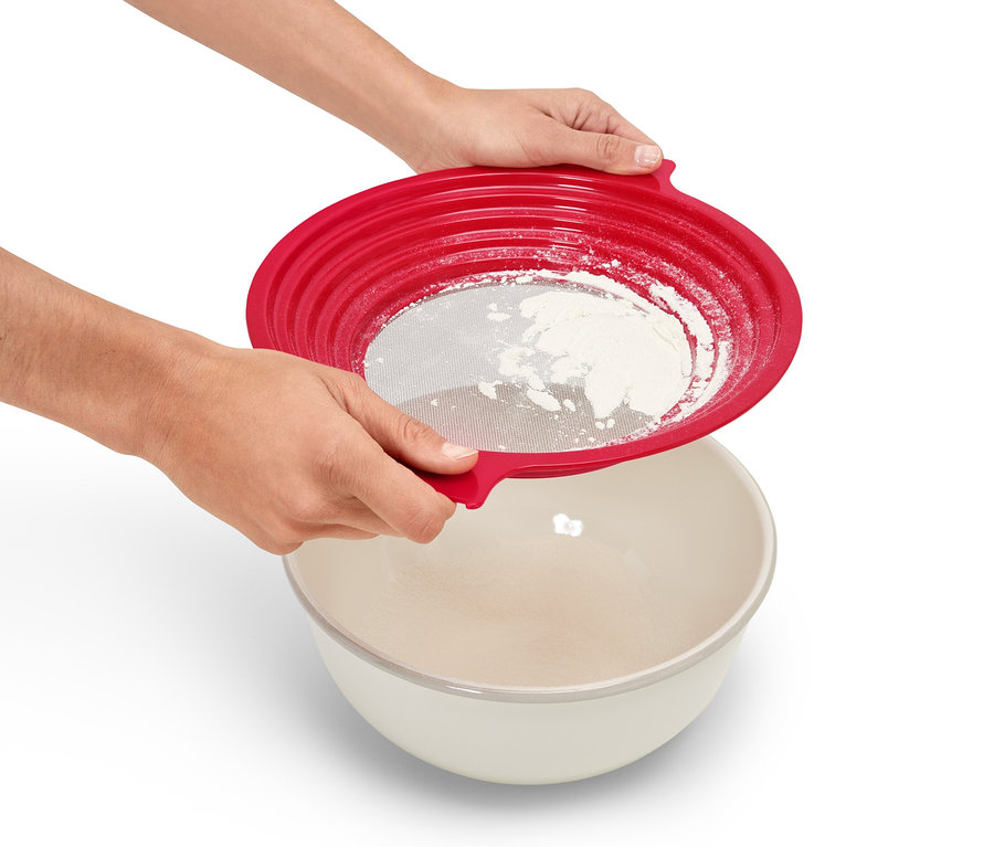 Osoba preosieva múku cez červené sito 2 v 1 do misy.