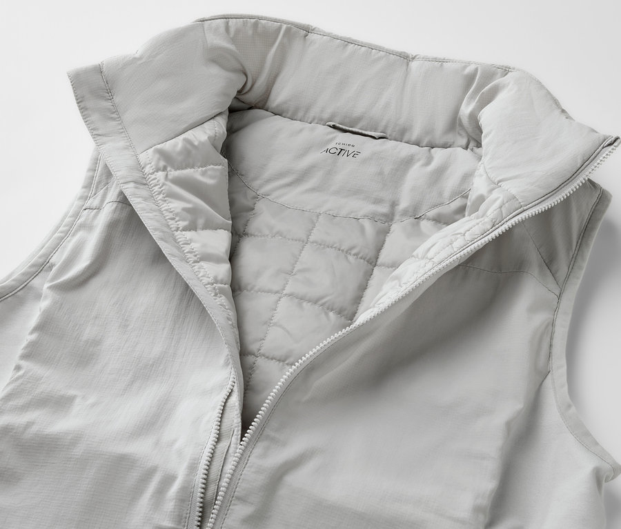 Svetlá hybridná vesta »pack light« s rozopnutým zipsom.