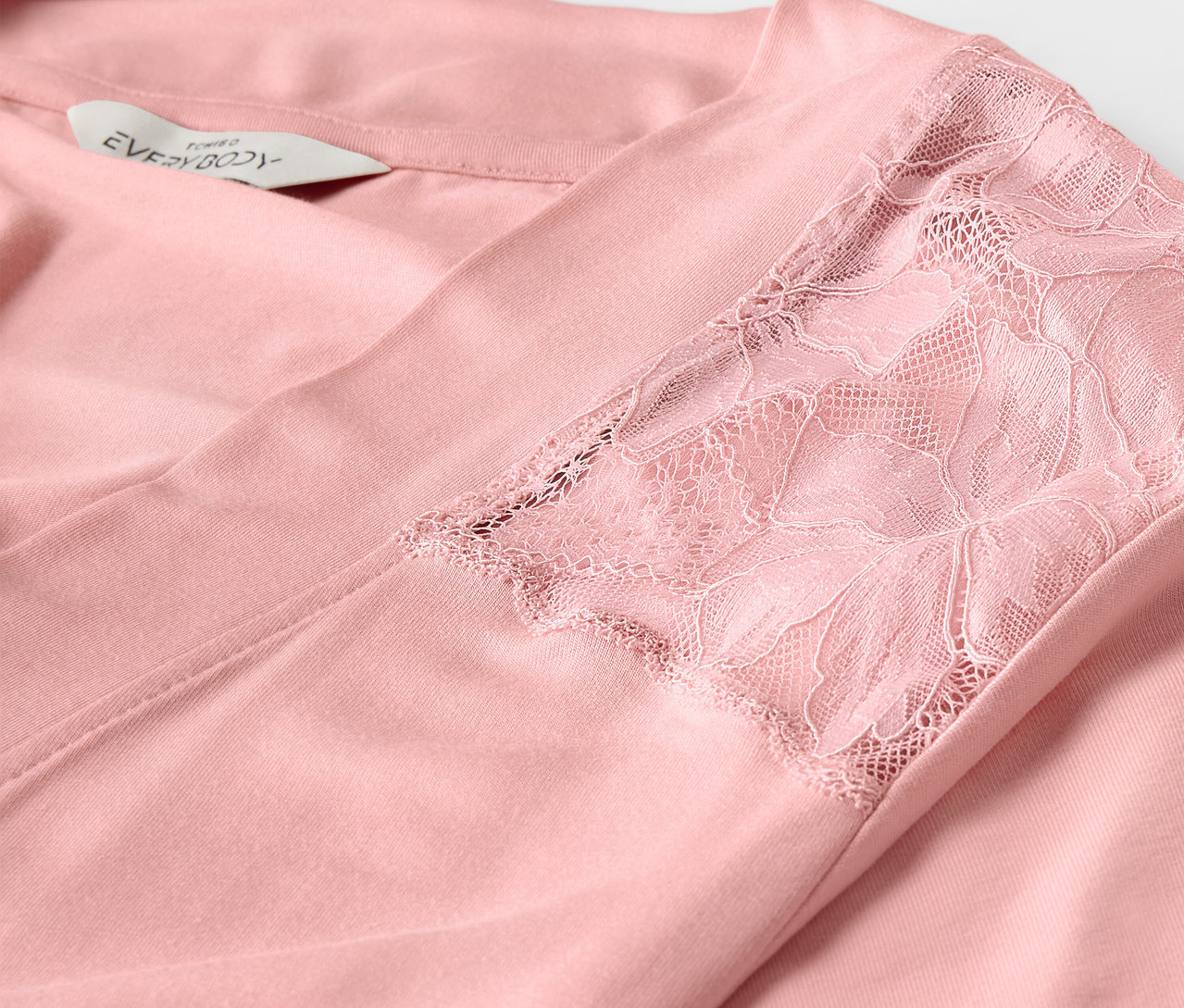 Detail ružového županu s čipkou na rukáve.