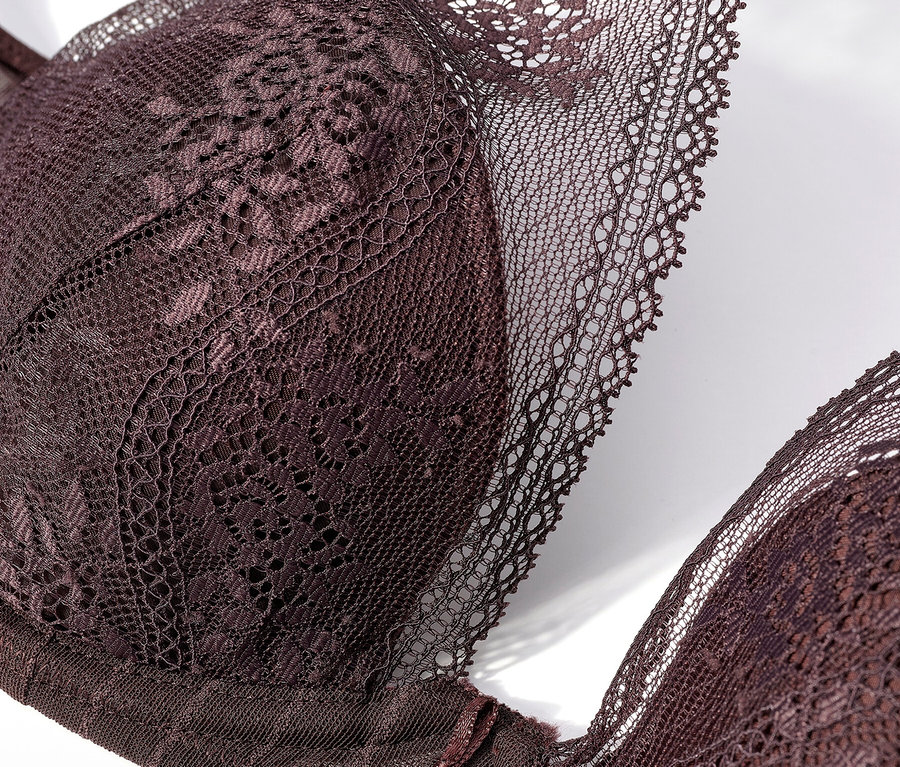 Detailný záber na čipkovanú podprsenku v tmavofialovom odtieni na bielom pozadí.