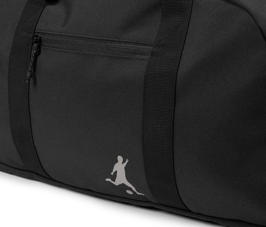Detail čiernej športovej tašky s vreckom na zips a logom osoby hrajúcej futbal.