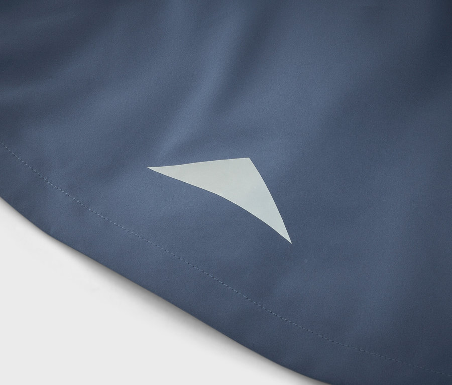 Detail modrej látky s trojuholníkovým reflexným prvkom.