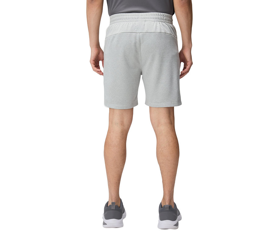 Pohľad zozadu na osobu v krátkych, svetlosivých šortkách a sivých bežeckých topánkach.