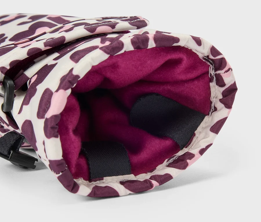 Detail rukavice s leopardím vzorom v bielej, ružovej a fialovej farbe, ukazujúci jej tmavoružovú flísovú podšívku a čierny popruh na boku.