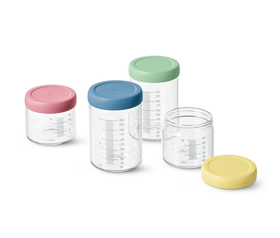 Štyri dávkovacie poháriky s farebnými viečkami a stupnicou.