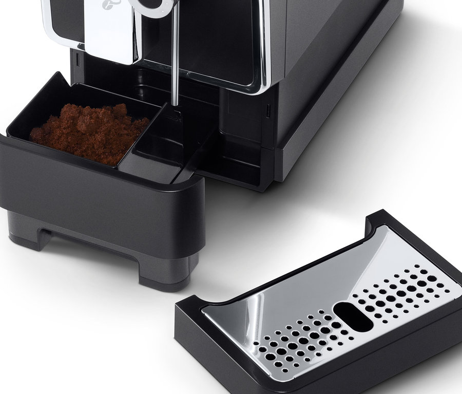 Detail plnoautomatického kávovaru Tchibo »Esperto Pro« v antracitovej farbe s vybratou nádobou na kávovú sedlinu a odkvapkávacou miskou.