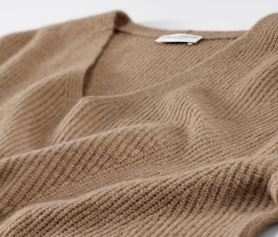 Detail pulóvra z hrubého úpletu vo farbe ťavej srsti.
