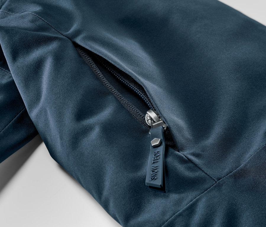 Detail námorníckej modrej lyžiarskej bundy so zipsom.