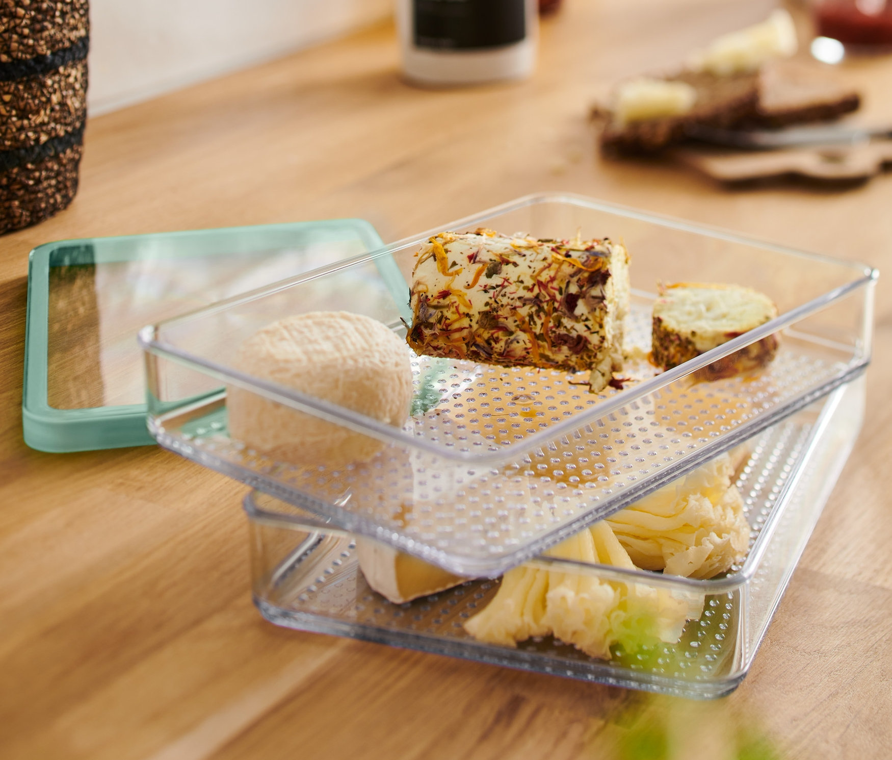 Dve priehľadné Nádoby na krájané potraviny naskladané na sebe s rôznymi syrmi.