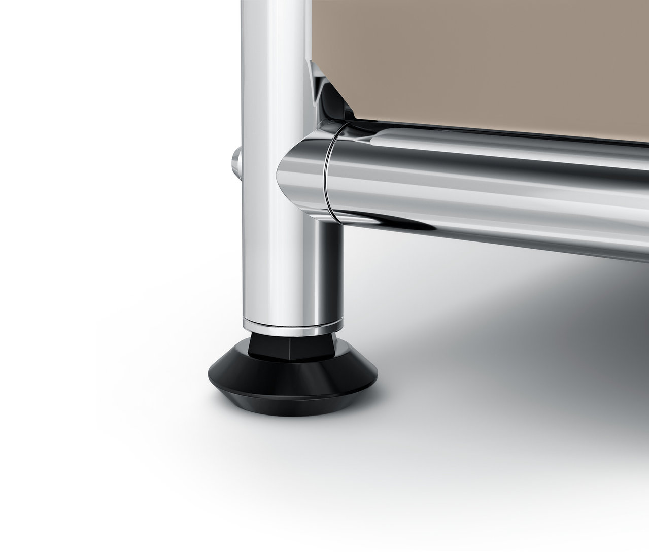 Detail chrómovanej nohy a čiernej pätky na bielom pozadí.