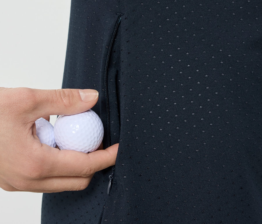 Ruka vkladá golfové loptičky do vrecka športových šiat.