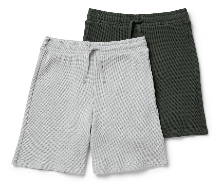 Dvoje vaflové šortky, jedny sivé a jedny tmavozelené, ležia na sebe.