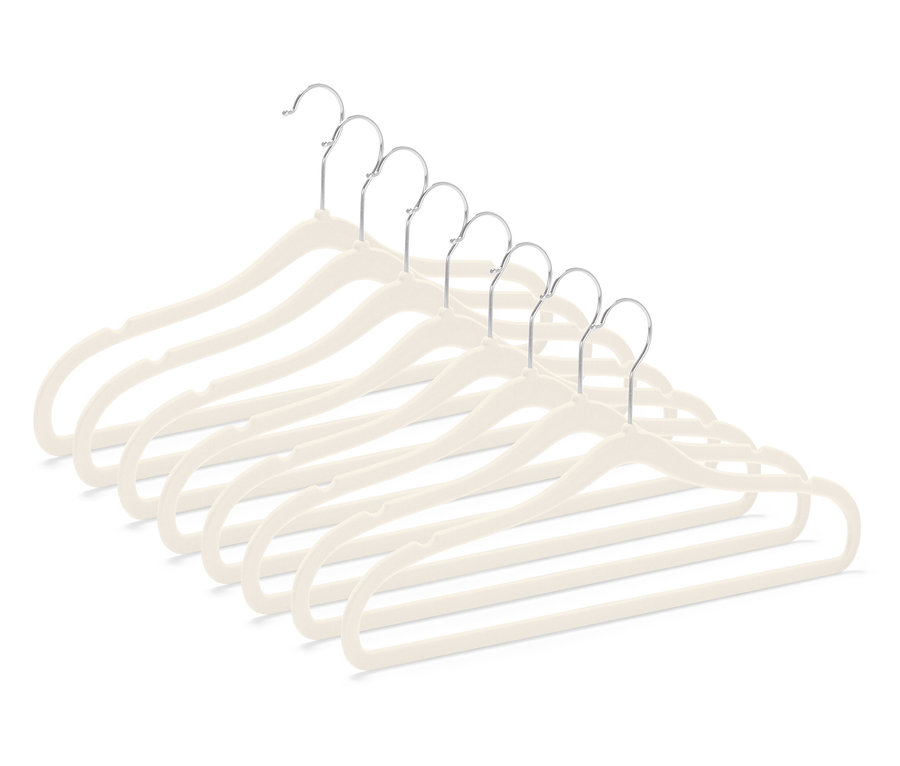 Sedem béžových zamatových vešiakov na odevy s chrómovanými háčikmi, usporiadaných diagonálne v pravom dolnom rohu.