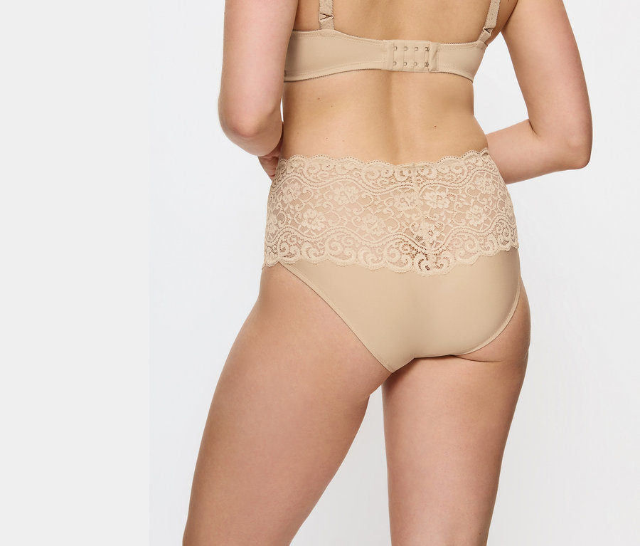 Pohľad zozadu na ženu v béžových čipkovaných nohavičkách s vysokým pásom a podprsenke.