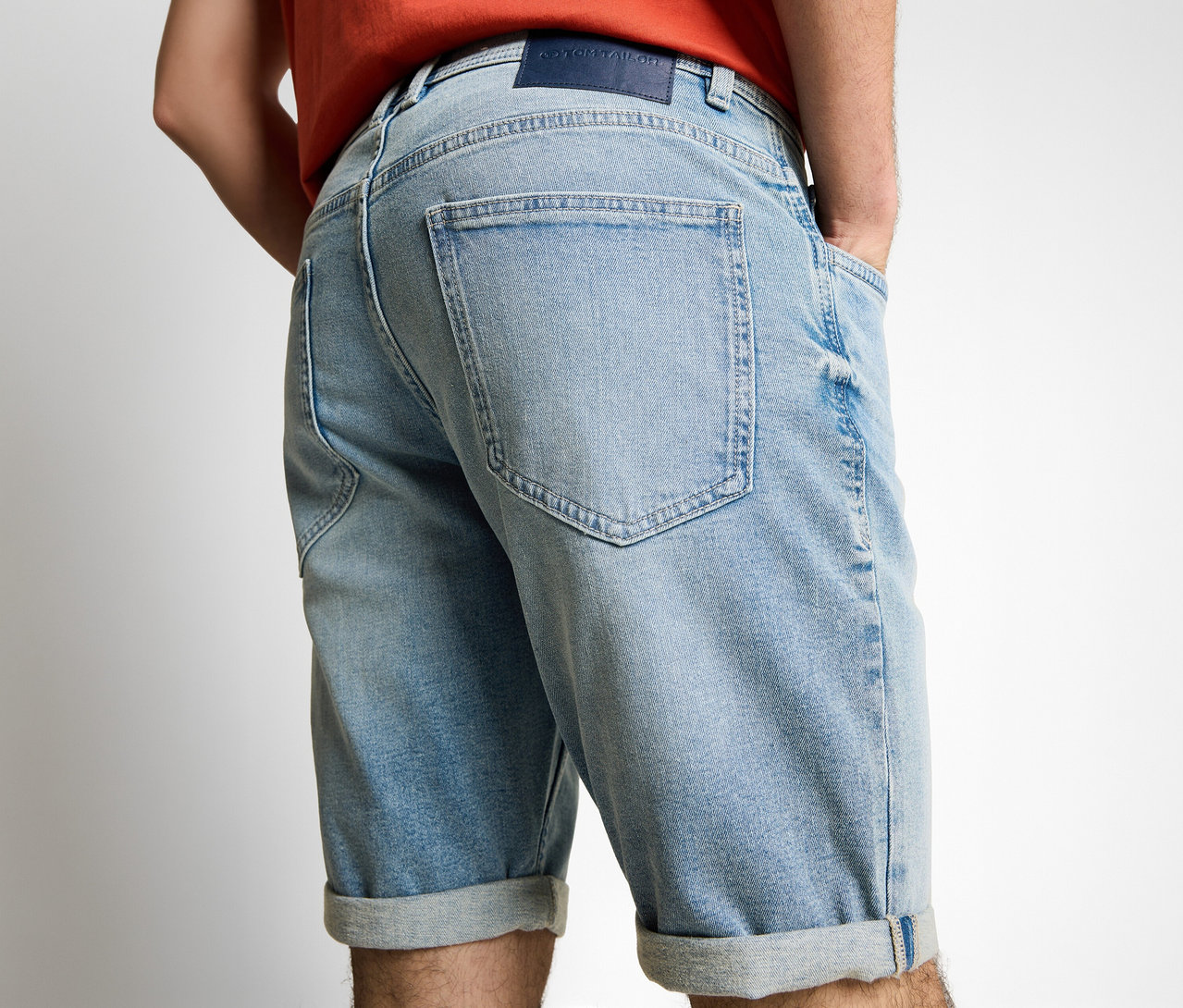 Muž zozadu v džínsových šortkách Tom Tailor TTJOSH REGULAR SLIM, light stone blue denim, s rukami vo vreckách.