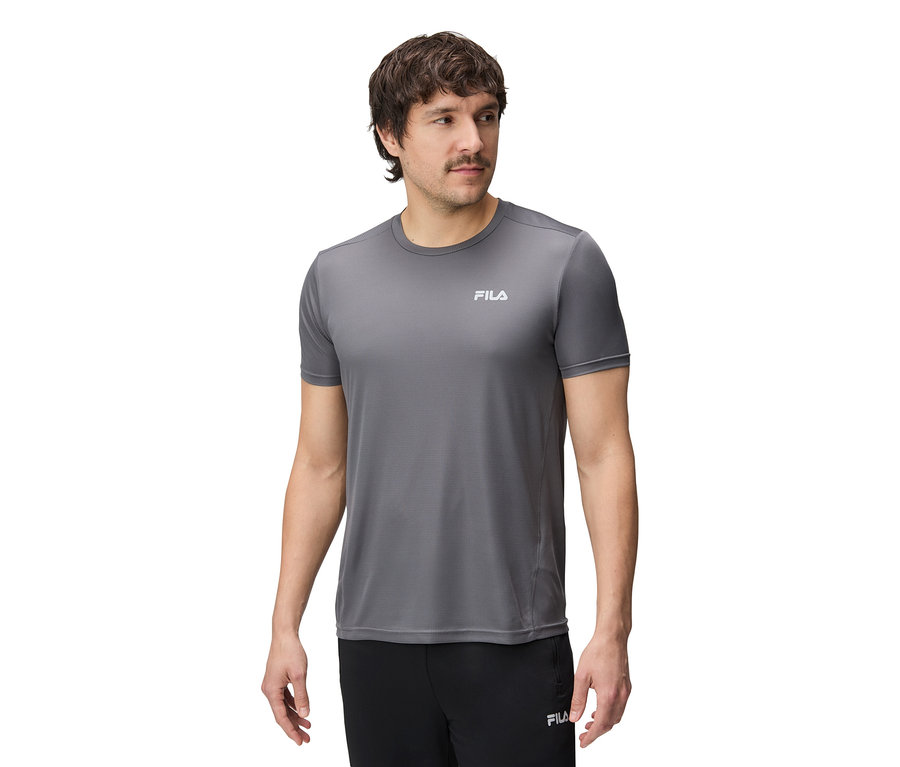 Muž má na sebe sivé tričko Fila a čierne nohavice.