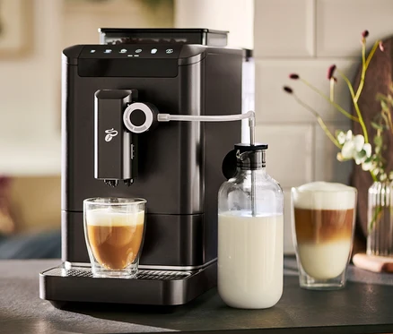Automatický kávovar »Esperto 2 Milk« Granite Black pripravuje kávu do pohára. Vedľa stojí karafa na mlieko.