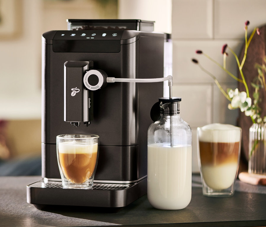 Automatický kávovar »Esperto 2 Milk« Granite Black pripravuje kávu do pohára. Vedľa stojí karafa na mlieko.