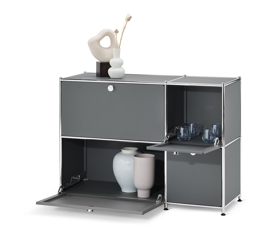 Sivá odkladacia skrinka »CN3« so 4 výklopnými dvierkami, s vázami a pohármi.
