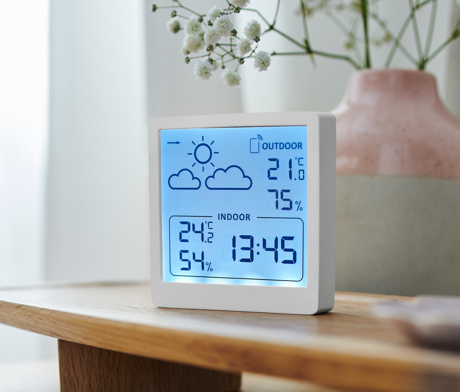 Biela meteostanica zobrazuje vnútornú a vonkajšiu teplotu a vlhkosť vzduchu.