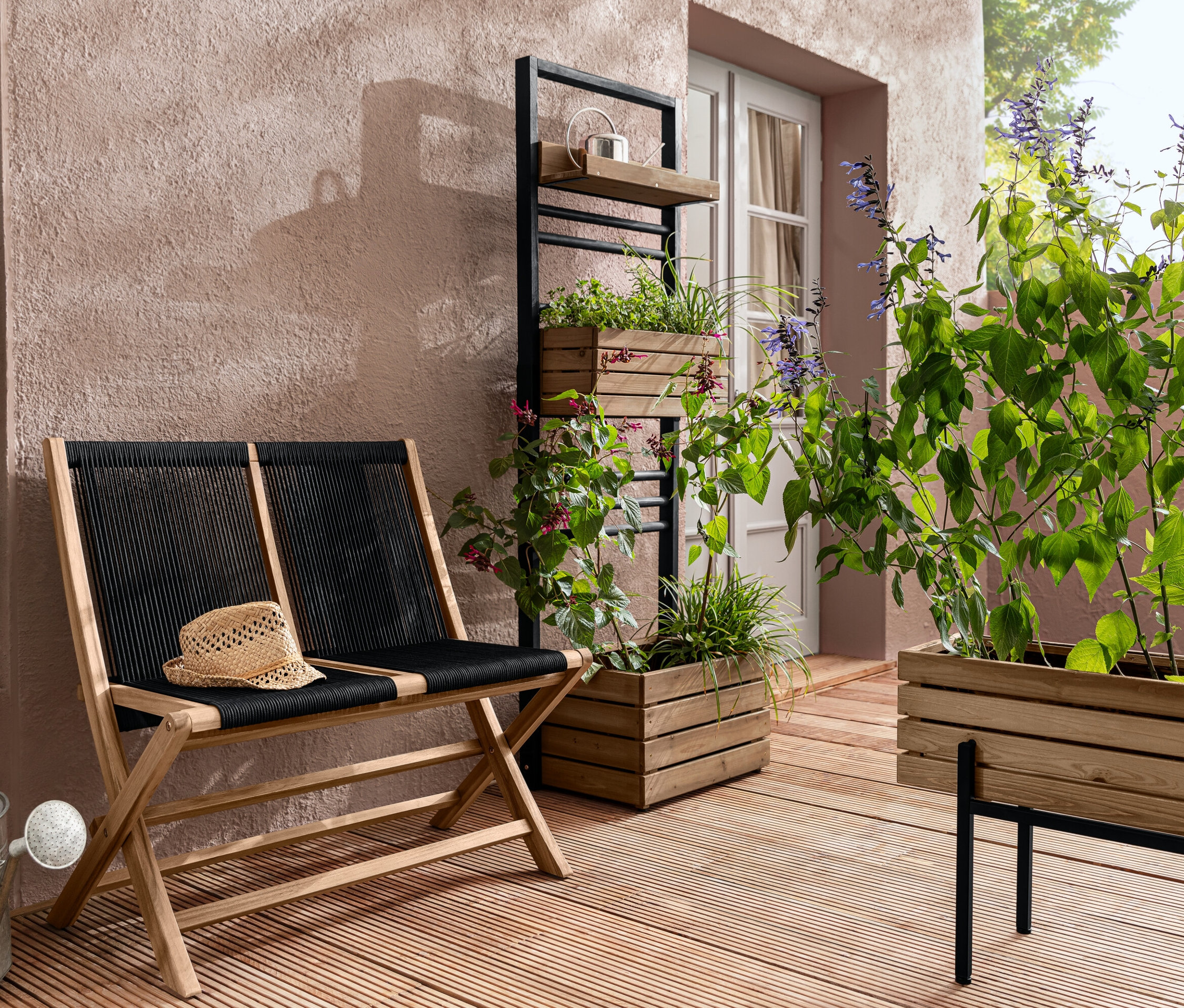 Skladacia záhradná lavička s textilným výpletom, stojan na kvetináče »Elin« a kvetináč »Elin« s rastlinami na terase.