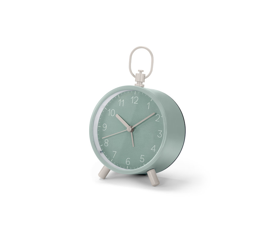 Mätovozelený Analógový dizajnový budík stojí na bielom povrchu.