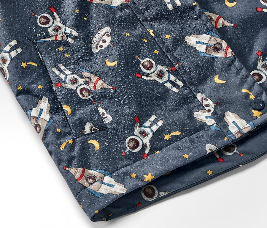Detail detskej tmavomodrej termobundy do dažďa s potlačou kozmonautov, rakiet a hviezd.