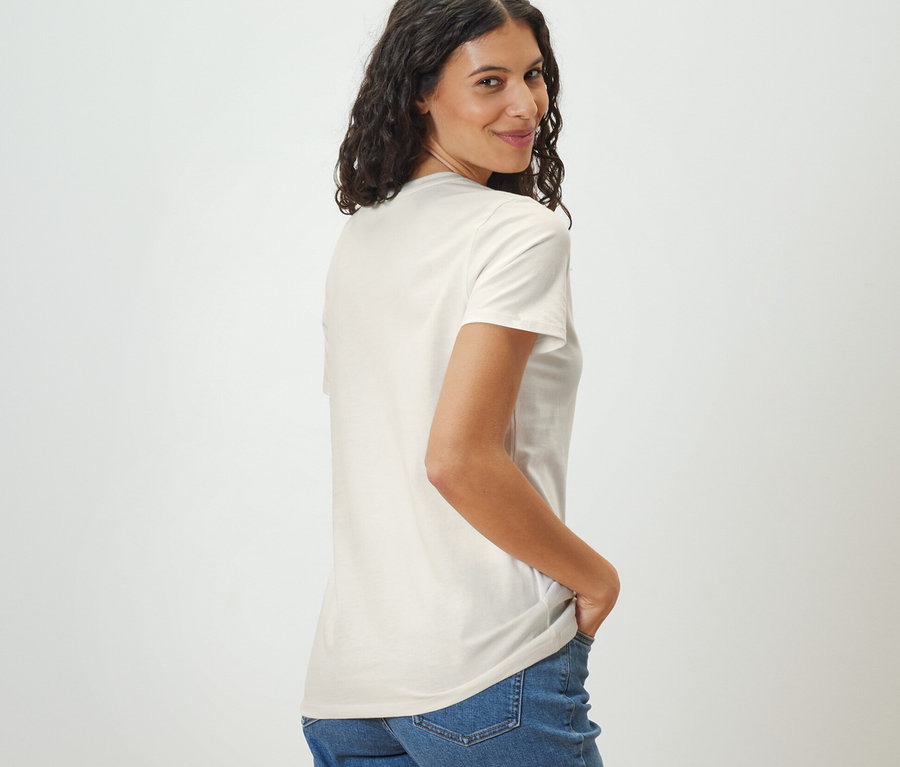 Žena sa pozerá cez plece a má na sebe biele tričko Basic.