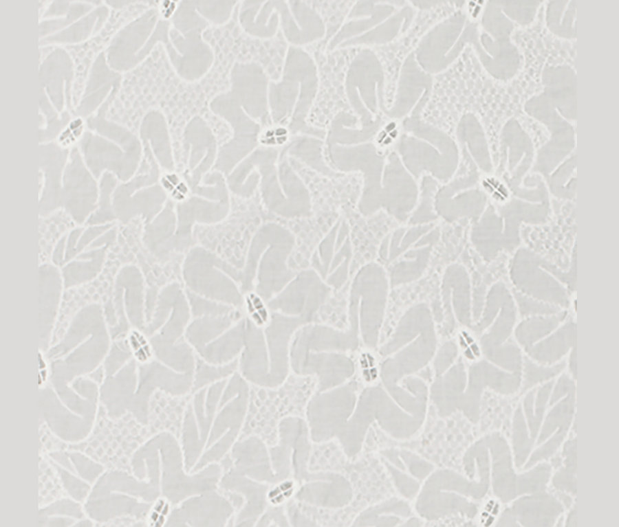 Detail bieleho blúzkového trička s výšivkou.