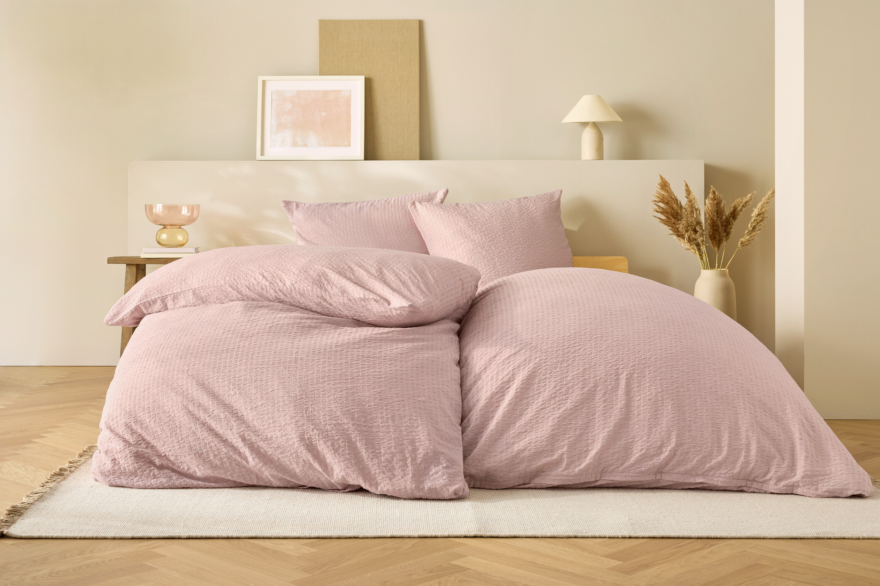 Ružové obliečky na posteli s béžovým pozadím.