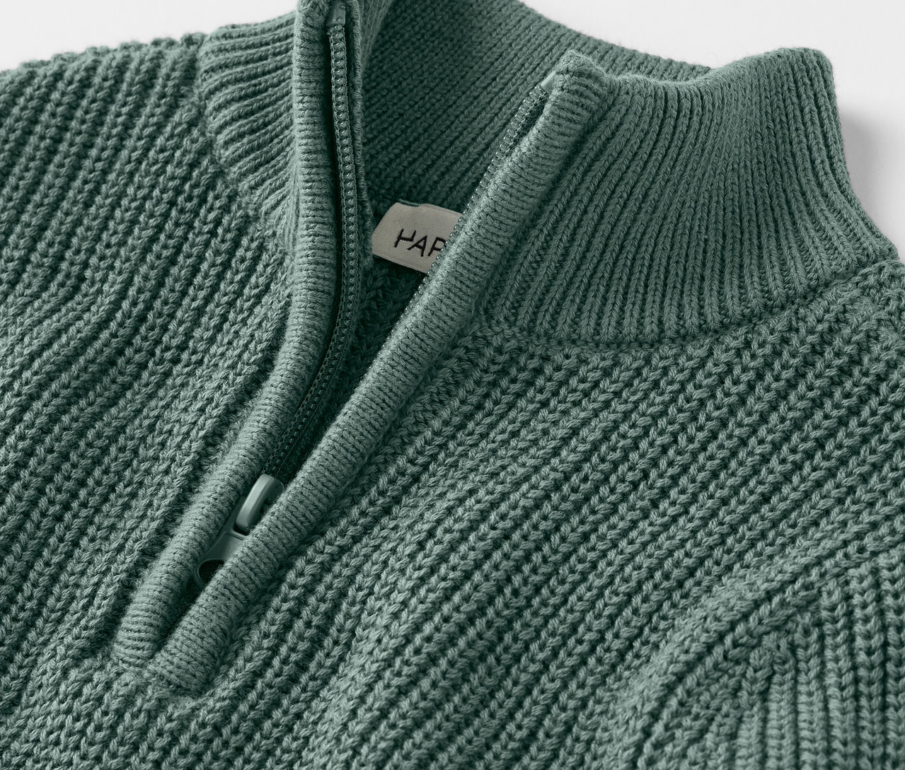 Detailný záber na detský pletený sveter troyer s krátkym zipsom.