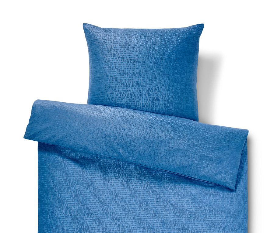 Modrá krepová posteľná bielizeň štandardnej veľkosti s vankúšom.